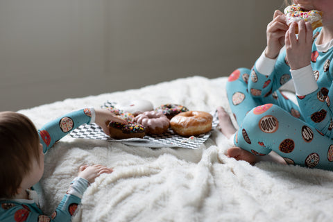 Two kids share a plate of donuts